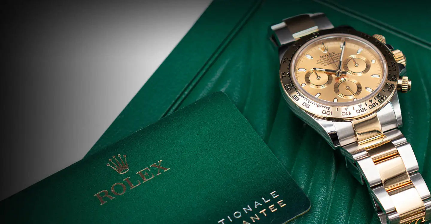 Gold and silver two-tone rolex daytona watch with a champagne-colored dial.