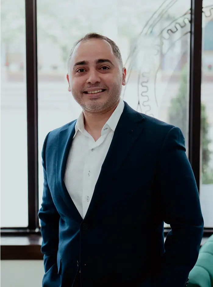 Man wearing a navy blue suit jacket over a white dress shirt.