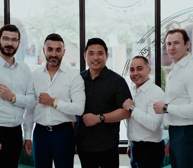 The men are wearing a variety of watches, including gold-toned and black models with different designs.
