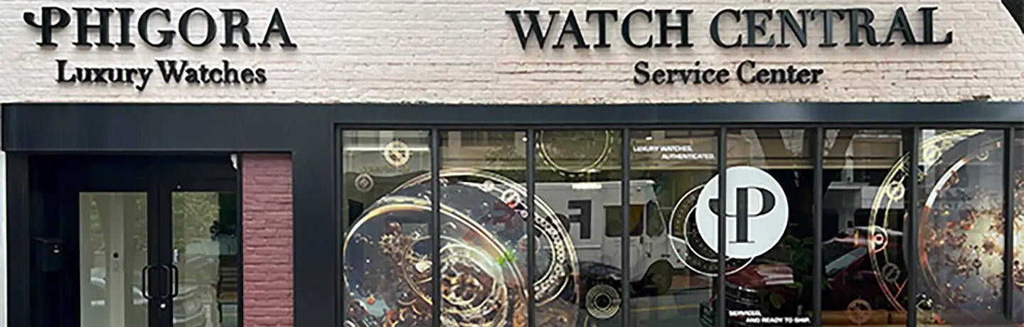 Phigora luxury watches storefront with black lettering on a light brick facade and large glass windows displaying watch dials.