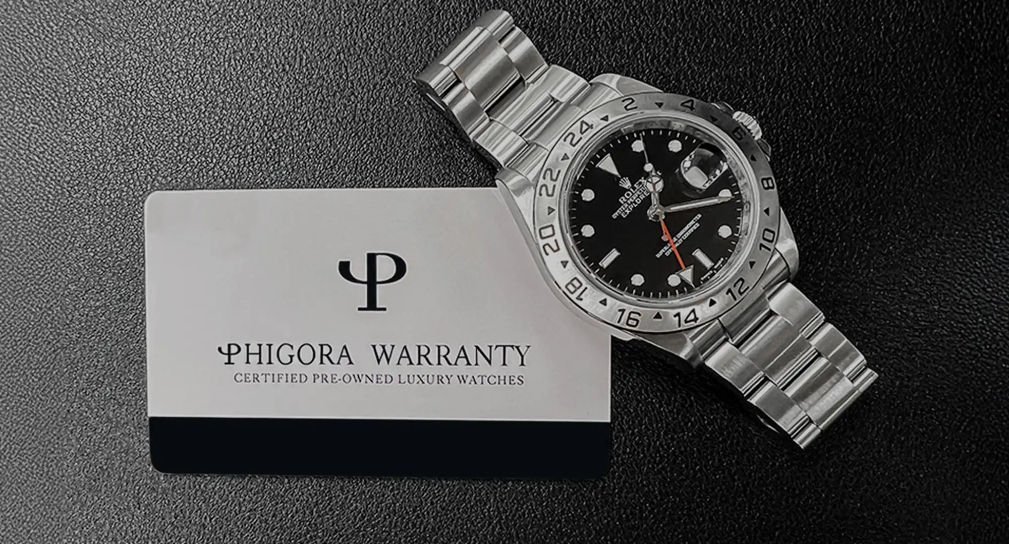 Silver stainless steel rolex explorer ii watch with a black dial, white hour markers, and an orange second hand.