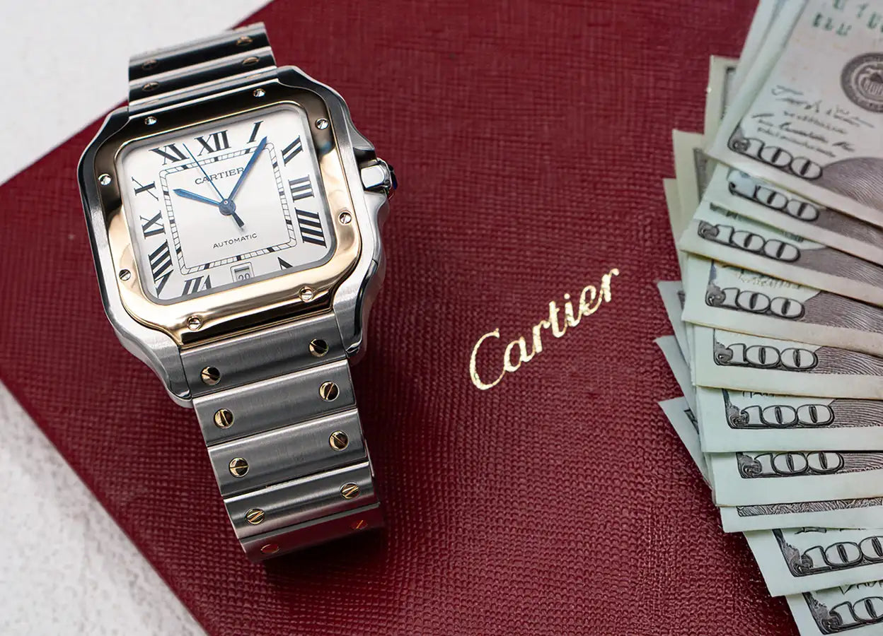 A sleek silver and gold cartier santos watch with a white dial, roman numerals, and an automatic movement.