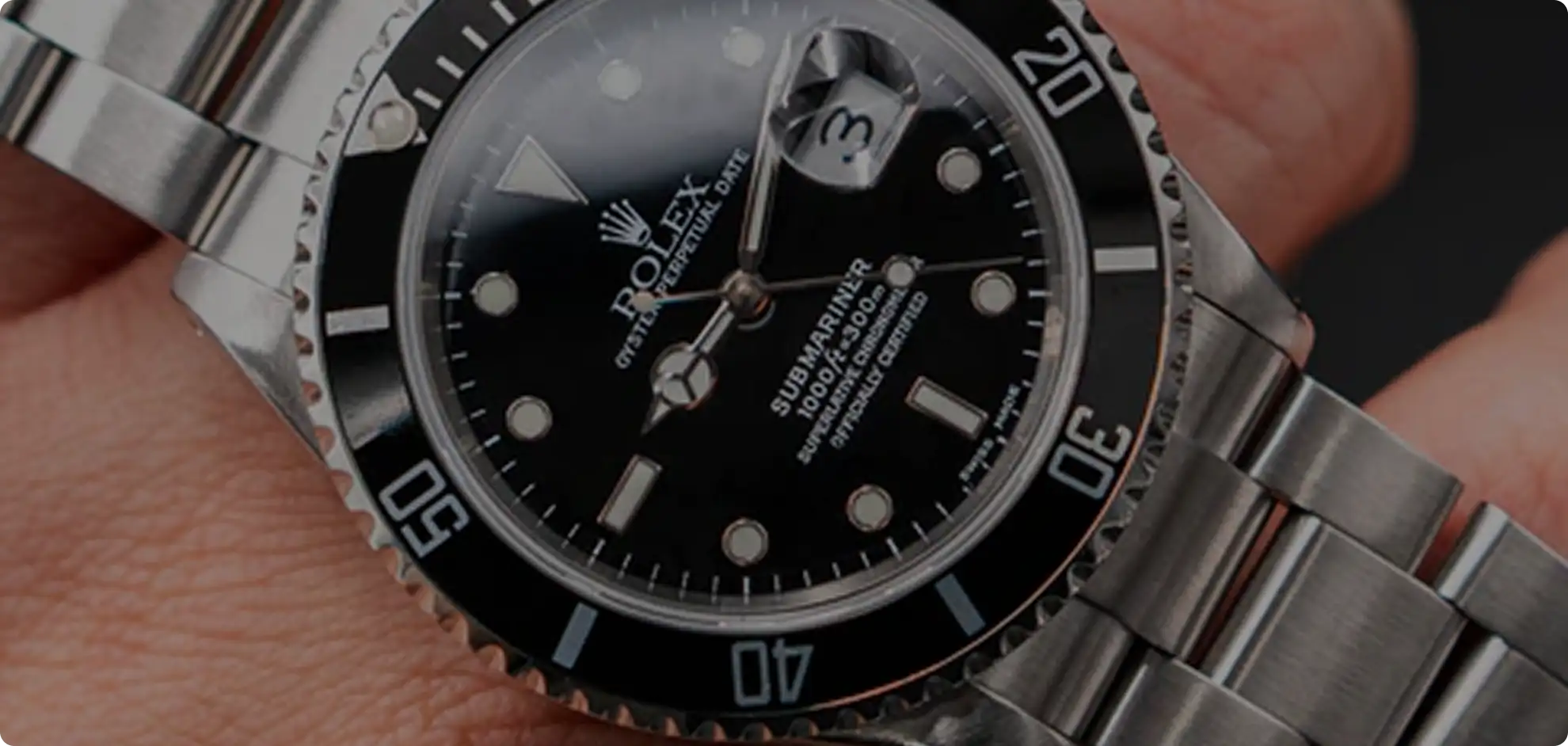 A sleek stainless steel rolex submariner watch with a black dial, luminous hour markers, and a unidirectional rotating bezel.