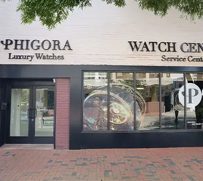 The storefront of phigora luxury watches, featuring a sleek black and white facade with large display windows showcasing an intricate watch design.